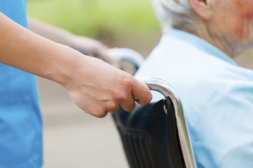 Nurse pushing patient in wheelchair Nurse pushing patient in wheelchair