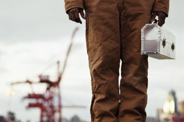 Worker holding metal lunch box Worker holding metal lunch box