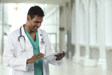 Doctor looks at patient information on tablet Doctor looks at patient information on tablet