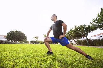 A man is working on his flexibility outside. A man is working on his flexibility outside.
