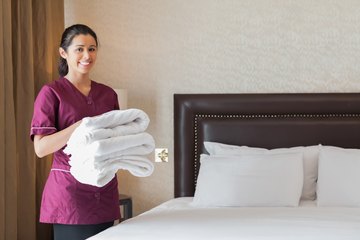 Chambermaid providing fresh towels in hotel room Chambermaid providing fresh towels in hotel room