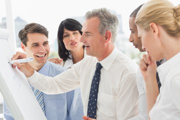 Co-workers playing a draw and guess game at the office. Co-workers playing a draw and guess game at the office.
