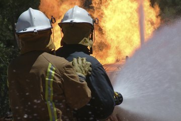 Firefighters spraying water on forest fire. Firefighters spraying water on forest fire.