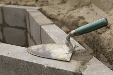 A trowel resting on a brick wall under construction A trowel resting on a brick wall under construction