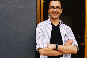 A server stands at the front door of an establishment. A server stands at the front door of an establishment.