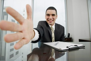 Close up of man dressed in a suit extending his hand for a handshake. Close up of man dressed in a suit extending his hand for a handshake.
