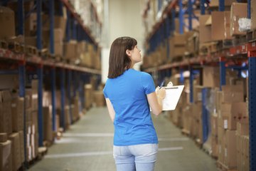 Warehousemen use inventory sheets as they count inventory in the main warehouse area. Warehousemen use inventory sheets as they count inventory in the main warehouse area.