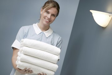 Housekeeper holding pile of freshly washed towels. Housekeeper holding pile of freshly washed towels.