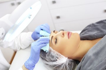 Esthetician providing skin-care treatment to patient Esthetician providing skin-care treatment to patient