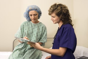 Nurse with patient signing consent form Nurse with patient signing consent form