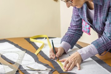 A clothing maker measuring fabric. A clothing maker measuring fabric.