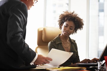 A boss speaks with an administrative assistant. A boss speaks with an administrative assistant.