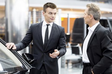 Car salesman talking to potential customer Car salesman talking to potential customer