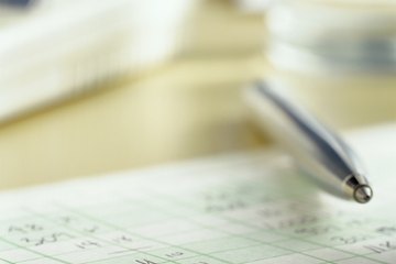 A close-up of an accounting ledger and an ink pen. A close-up of an accounting ledger and an ink pen.