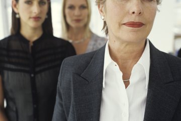 An older businesswoman poses with some younger colleagues. An older businesswoman poses with some younger colleagues.