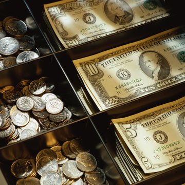 Cash drawer filled with US dollars and coins