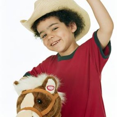 Digital Vision/Valueline/Getty Images Provide your child with a cowboy hat to enhance the ride on the hobby horse.