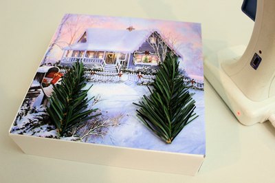 Hot glue miniature trees to the box lid.