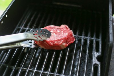 Putting a top sirloin steak on a grill.