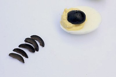 Black olives become the body and legs of the spiders.