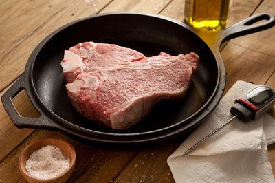 Raw steak in cast-iron skillet.