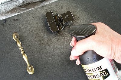 Stand handles on their screws pushed into foam board to paint.