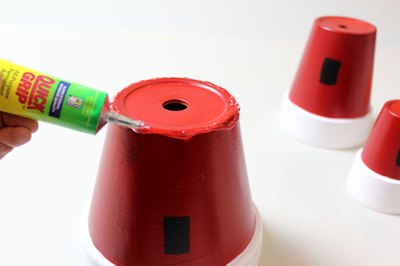 Apply adhesive to the base of the large pot