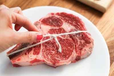 Rib steak tied in place with twine.