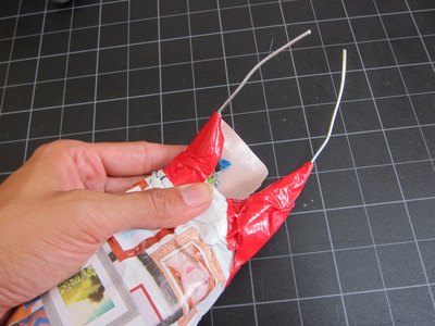 Tape the wire to the newspaper.