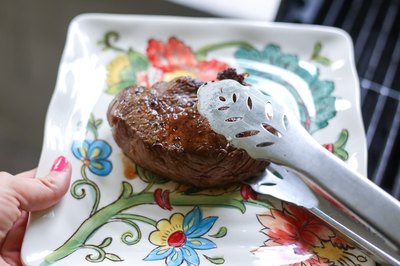 Plating a top sirloin steak.