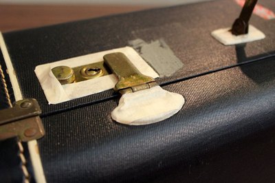 Cover luggage hardware with masking tape