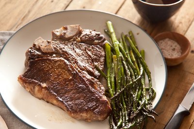T-Bone steak on plate with asparagus.