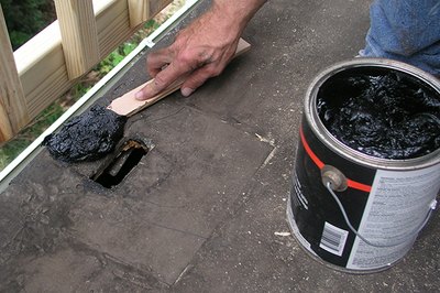 Spread the roofing cement all around the hole.
