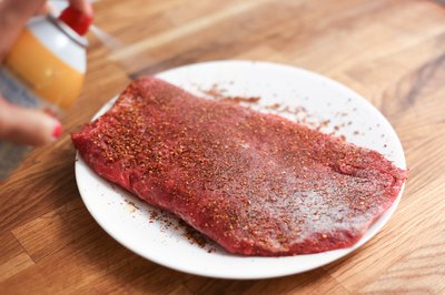 Seasoned skirt steak sprayed with cooking oil.