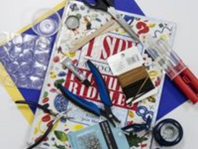 Supplies for bottle cap necklaces.