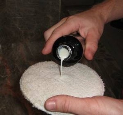 Loading the hand buffing pad to apply polish.