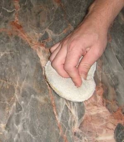 After polish dries, using hand buffing pad to rub scratched area.