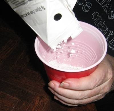 Pouring plaster into a disposable cup.