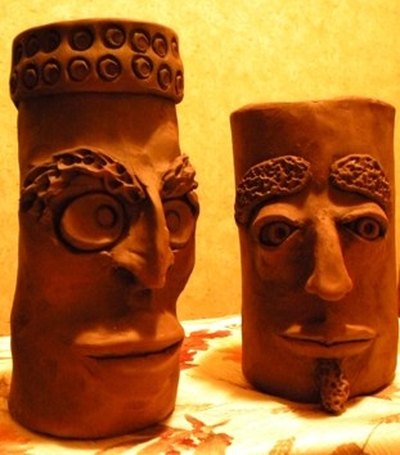 Grotesque face jugs fired in homemade outdoor kiln
