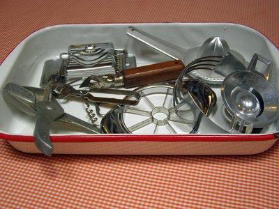 A shallow container holds kitchen tools.
