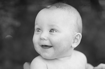 The baby grins and coos happily.