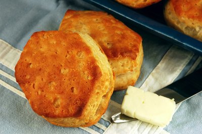 Top buttermilk biscuits with white cream gravy for a Southern brunch treat.