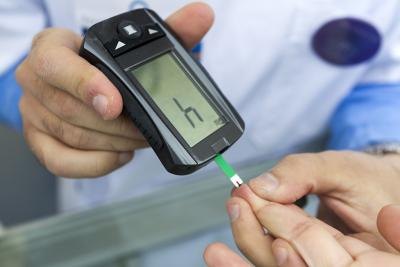 Measuring blood sugar with a glucometer.