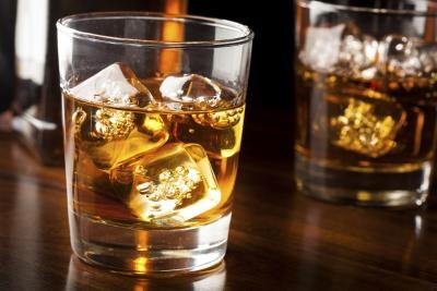 A glass with whiskey on the rocks.