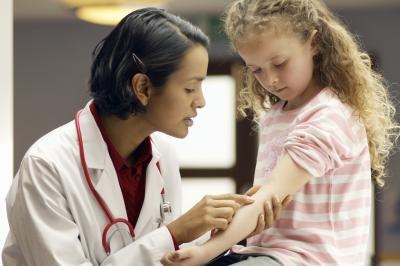 doctor looking at child's skin