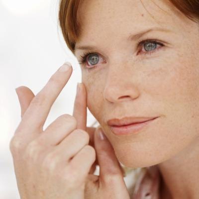 Adult woman putting in contact lens.