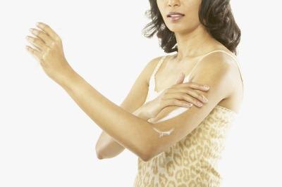 Woman putting on lotion to prevent itching.