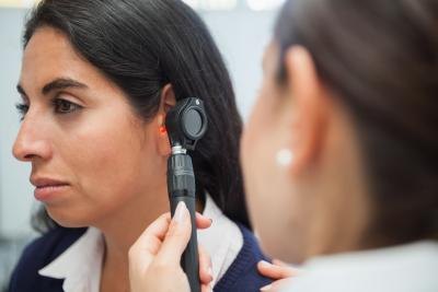 Female doctor examining female patient's inner ear.