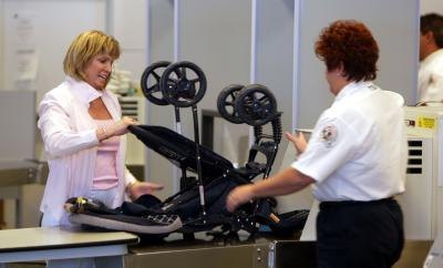 Woman with stroller is inspected by TSA agent
