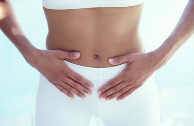 Woman with hands on abdomen.